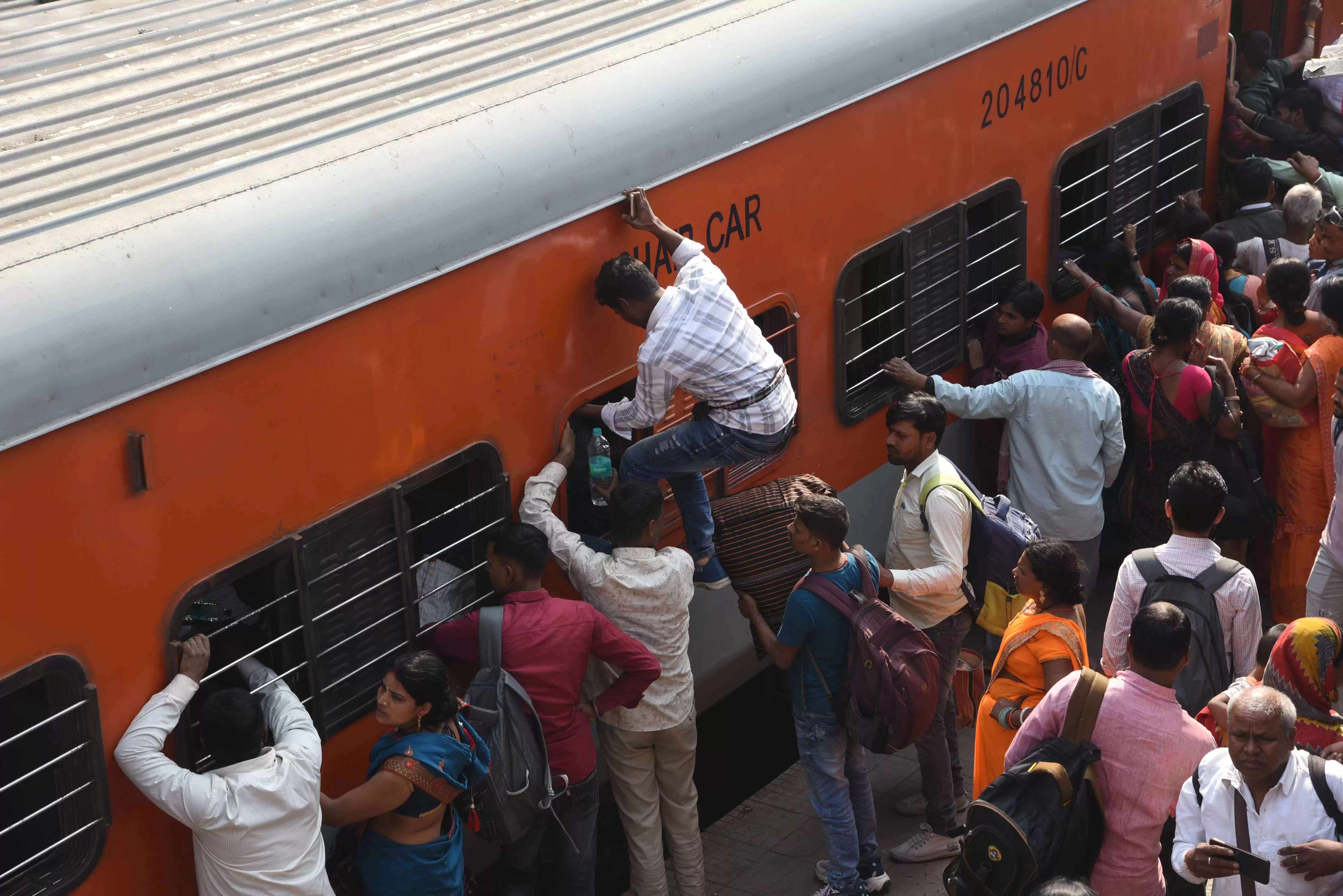 कई ट्रेनें रद्द होने से प्रयागराज में चल रहे महाकुंभ मेले में जाने के लिए यात्री आपातकालीन खिड़की से चढ़ने की कोशिश करते