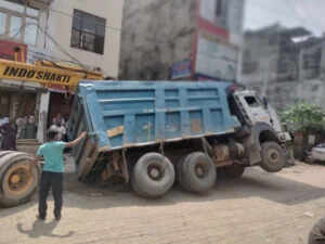 बजरी से भरा ट्रक सड़क धंसने से फंसा, क्षेत्र में मची अफरा-तफरी