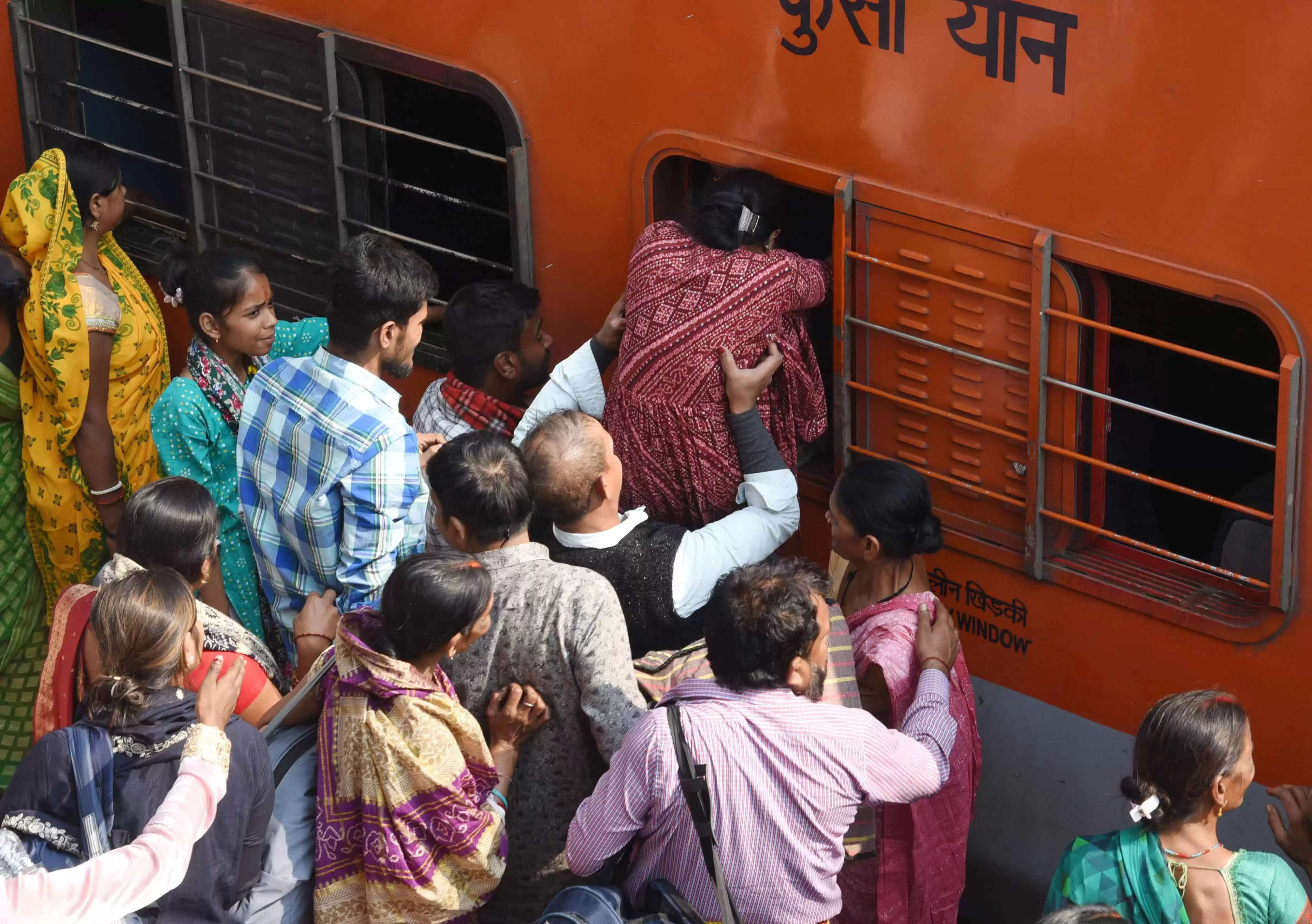 कई ट्रेनें रद्द होने से प्रयागराज में चल रहे महाकुंभ मेले में जाने के लिए यात्री आपातकालीन खिड़की से चढ़ने की कोशिश करते