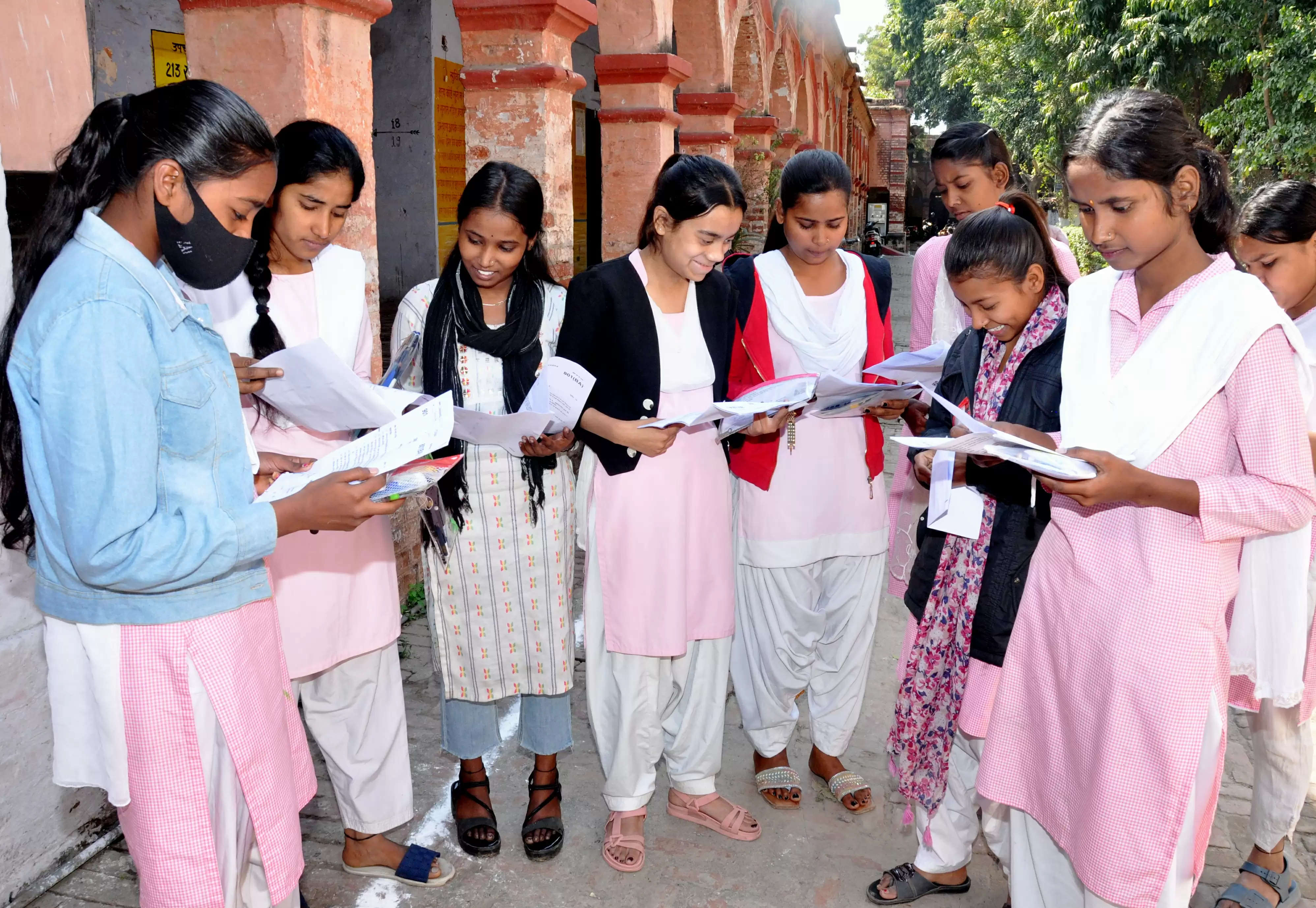 कानपुर में यूपी बोर्ड परीक्षा देकर लौटती छात्राएं आपस में प्रश्न और उत्तरों का मिलन करते हुए का छायाचित्र