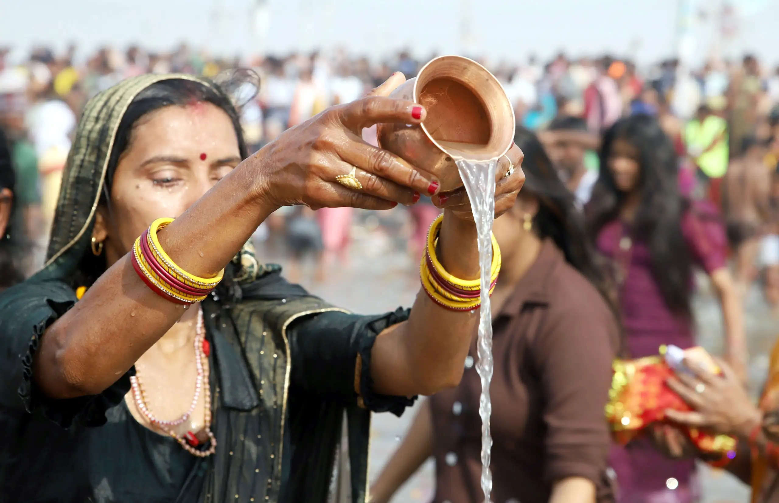 महाकुम्भ में स्नान के बाद भगवान सूर्य को जल चढ़ाती श्रद्वालु