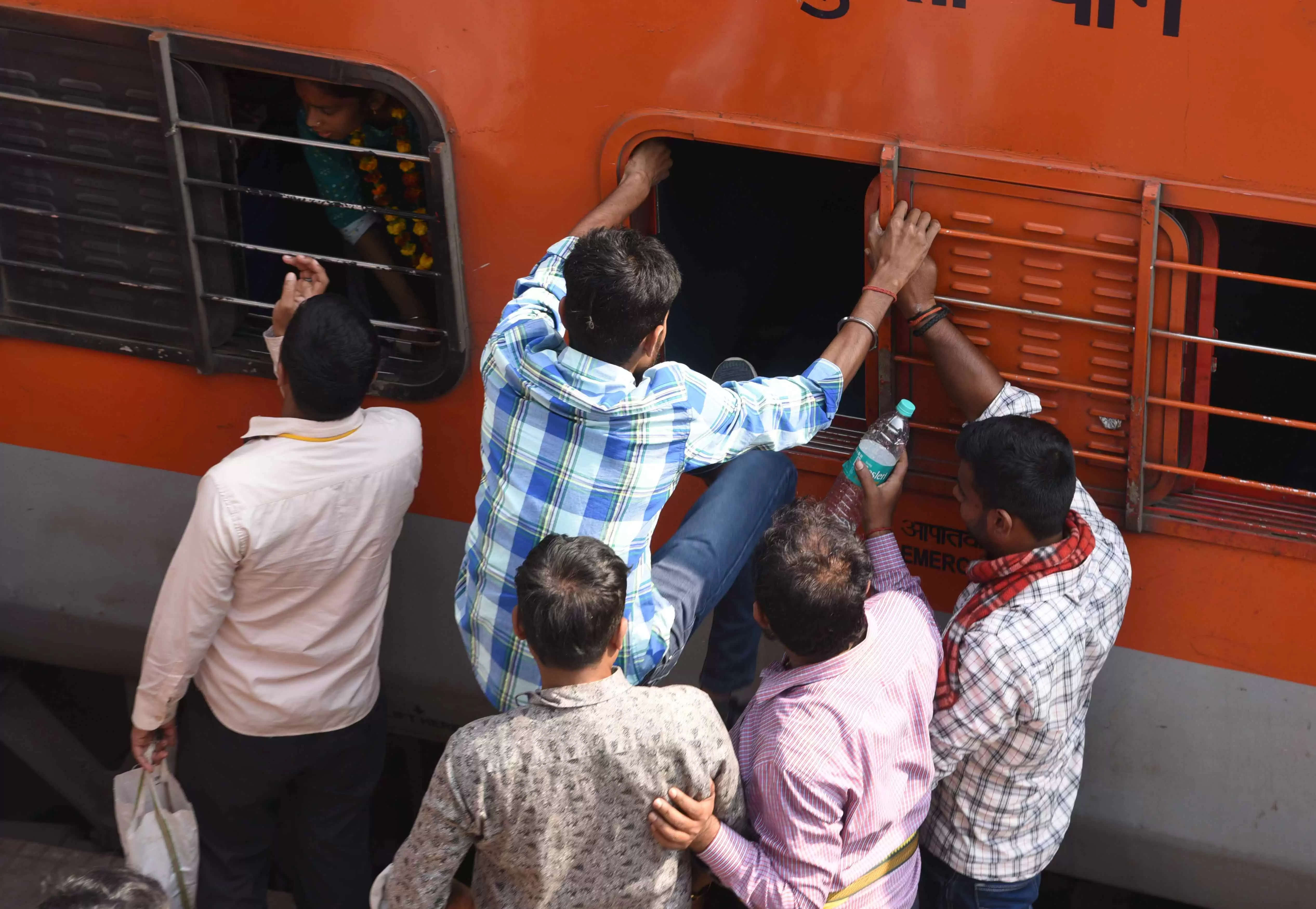 कई ट्रेनें रद्द होने से प्रयागराज में चल रहे महाकुंभ मेले में जाने के लिए यात्री आपातकालीन खिड़की से चढ़ने की कोशिश करते